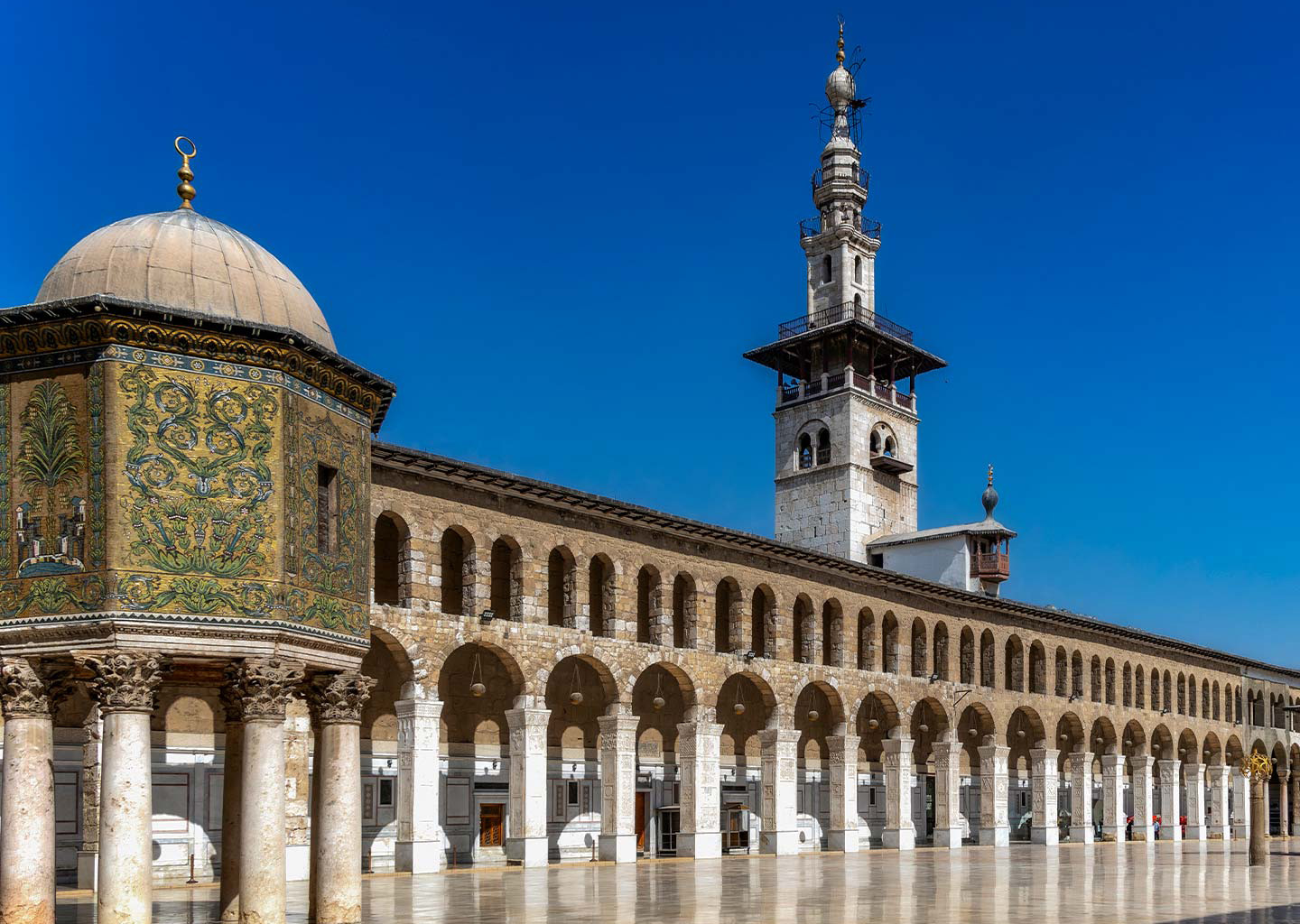 In the photograph, the main courtyard of the iconic Umayyad Mosque of Damascus takes center stage, while an exquisite minaret graces the background, creating a captivating scene.