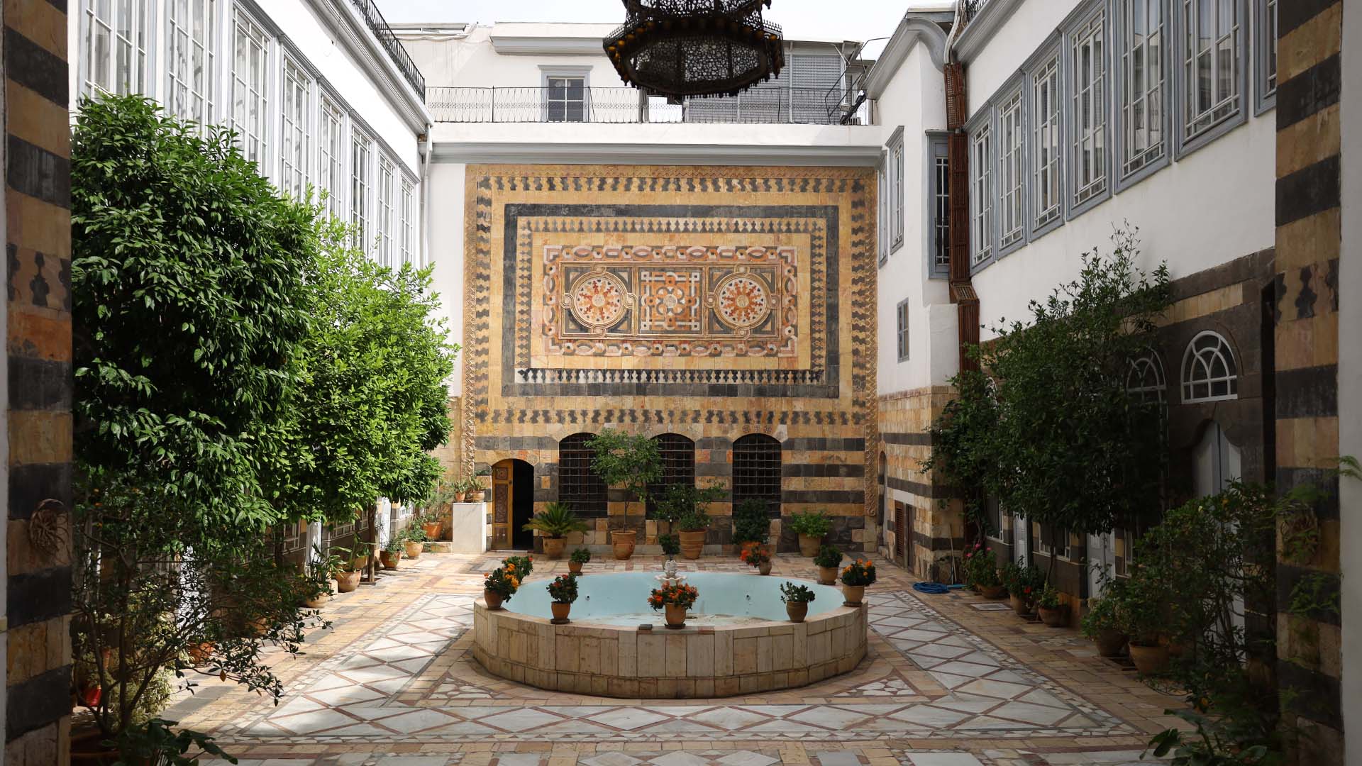 The photograph captures the alluring ambiance of the main courtyard of The Danish Institute of Damascus, an architectural gem gracefully nestled within the old Damascus.
