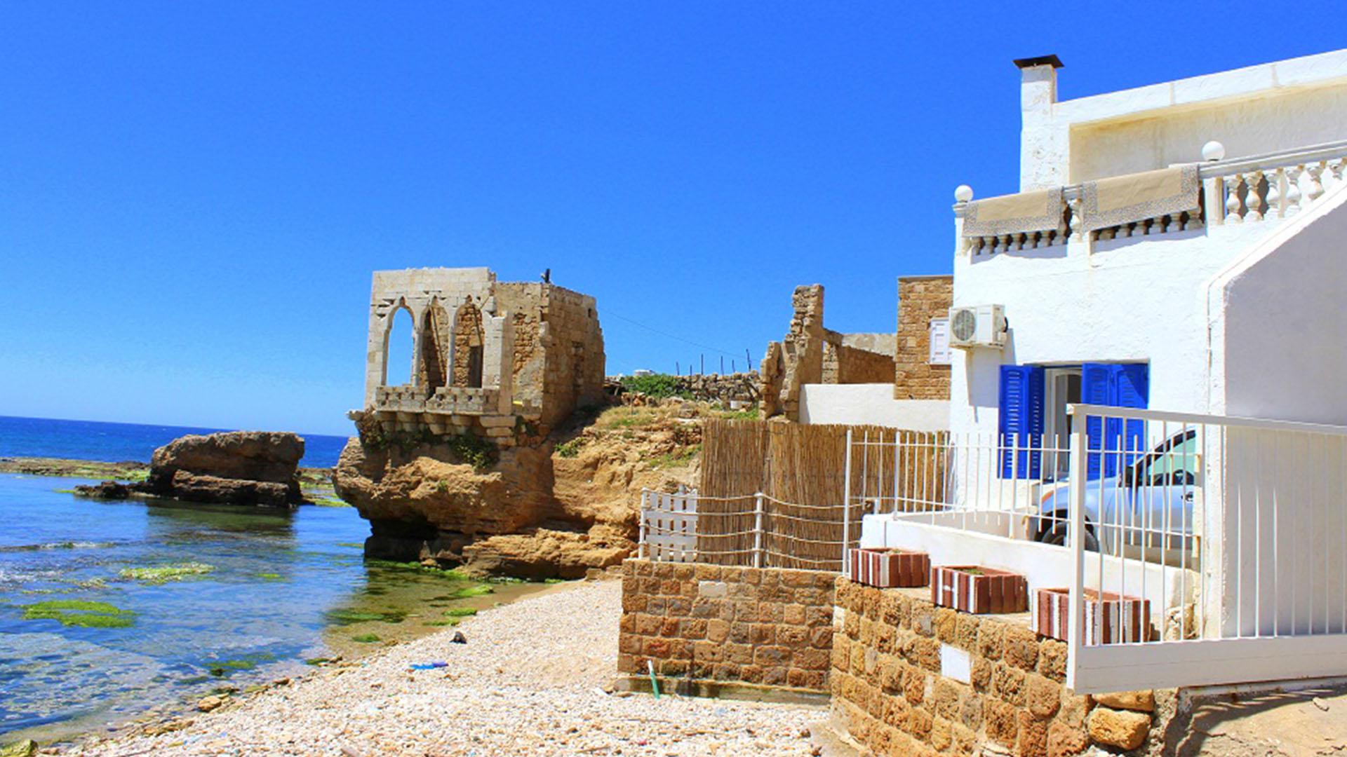 A photograph showcases the enchanting coastal town of Batroun, nestled along the shores of the Mediterranean Sea.