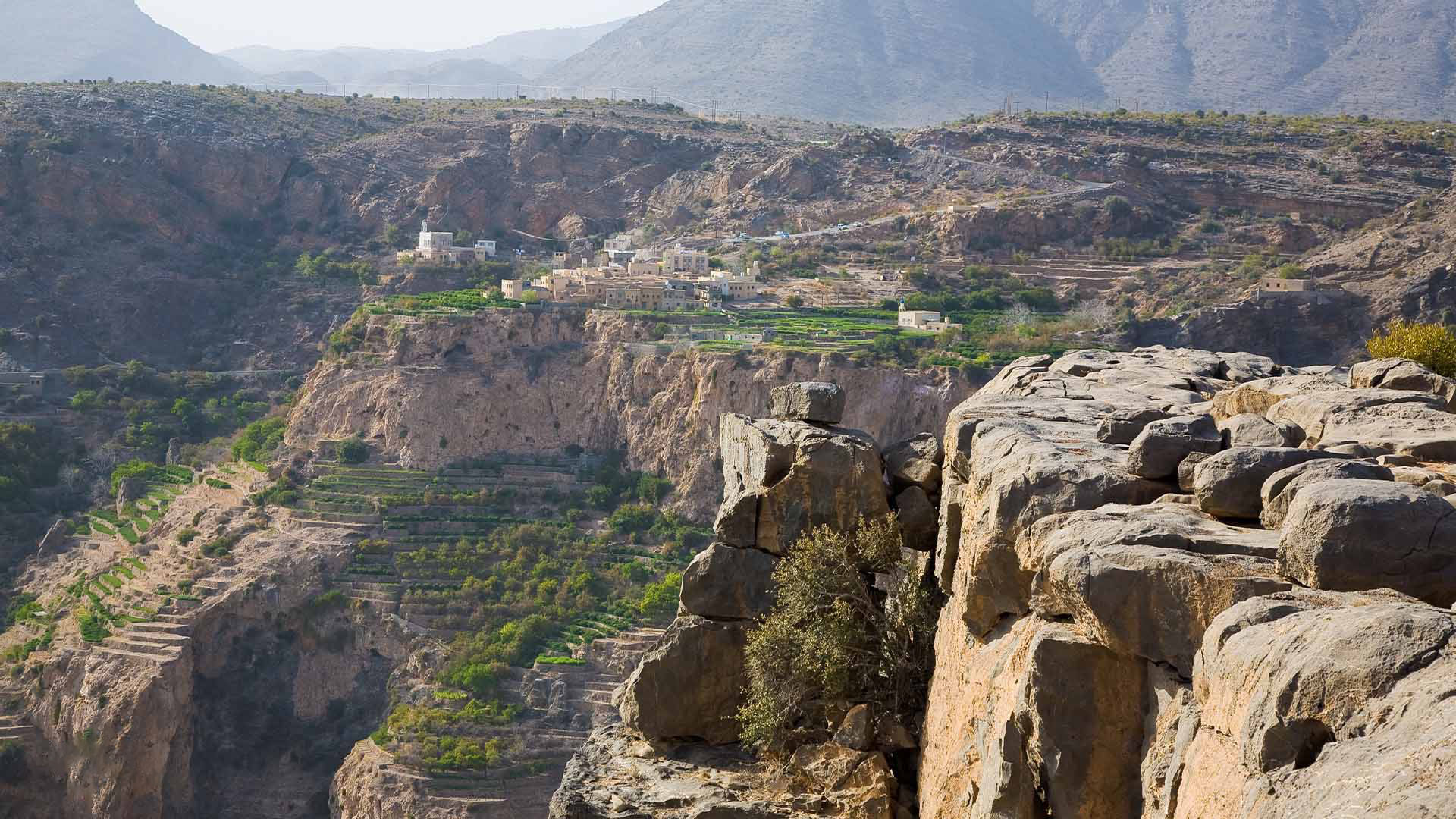 In a panoramic photograph, the captivating beauty of Jebel Akhdar is showcased, as it unveils picturesque natural landscapes that captivate the senses and leave a lasting impression.