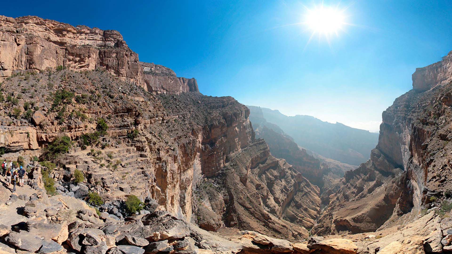 A panoramic photograph captures the eternal magnificence of Jebel Shams, nestled within the Al Hajar mountain range, offering awe-inspiring vistas of a majestic mountain range.