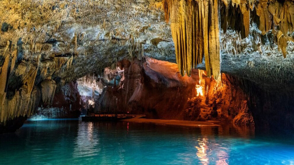 A photograph captures the awe-inspiring beauty of Jeita Grotto, where intricate limestone formations and hidden wonders beneath the surface create a mesmerizing spectacle.
