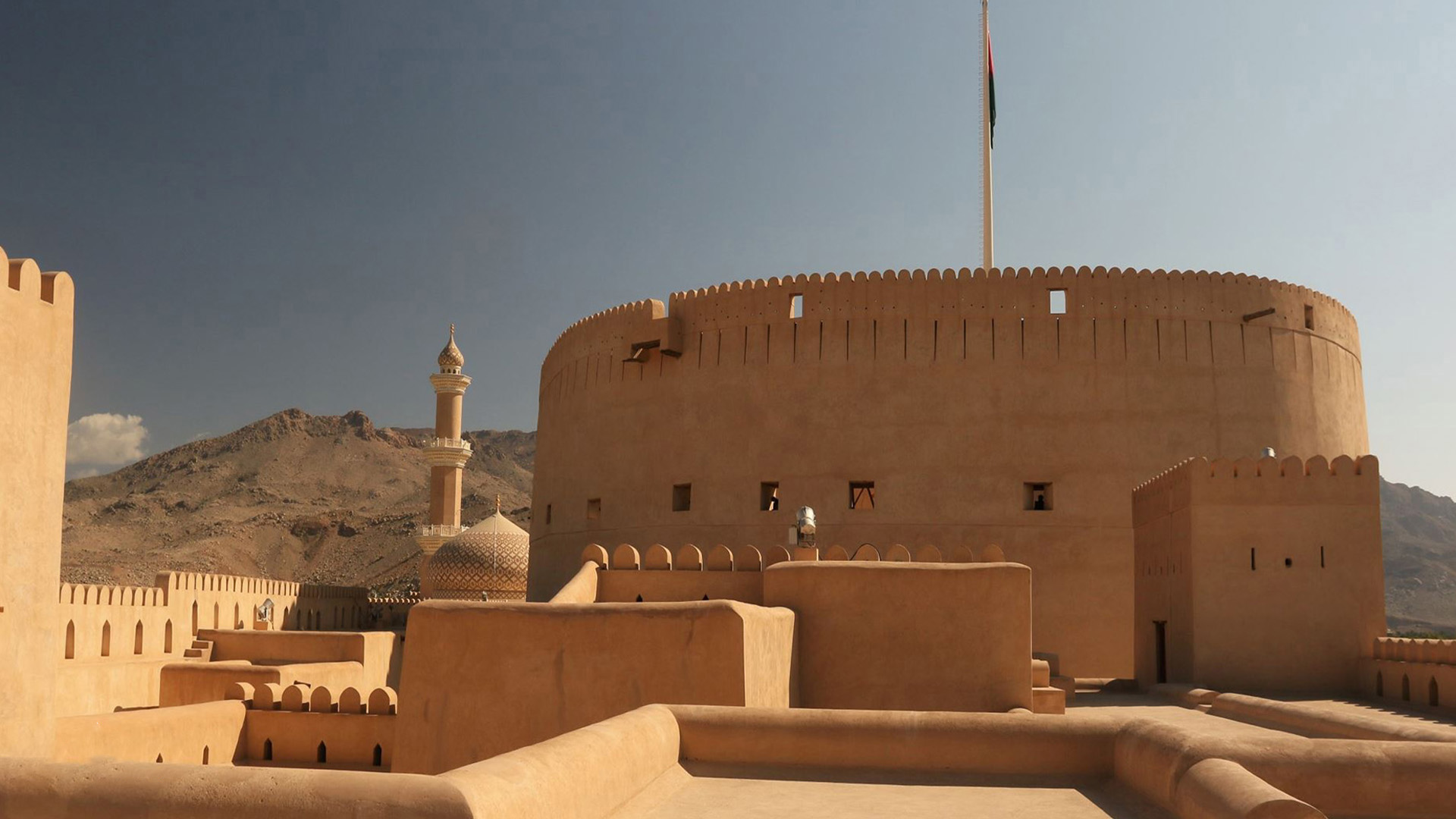 In a panoramic photograph, the grandeur of Nizwa Fort is captured, representing an architectural masterpiece that stands as a symbol of the city's rich historical significance.