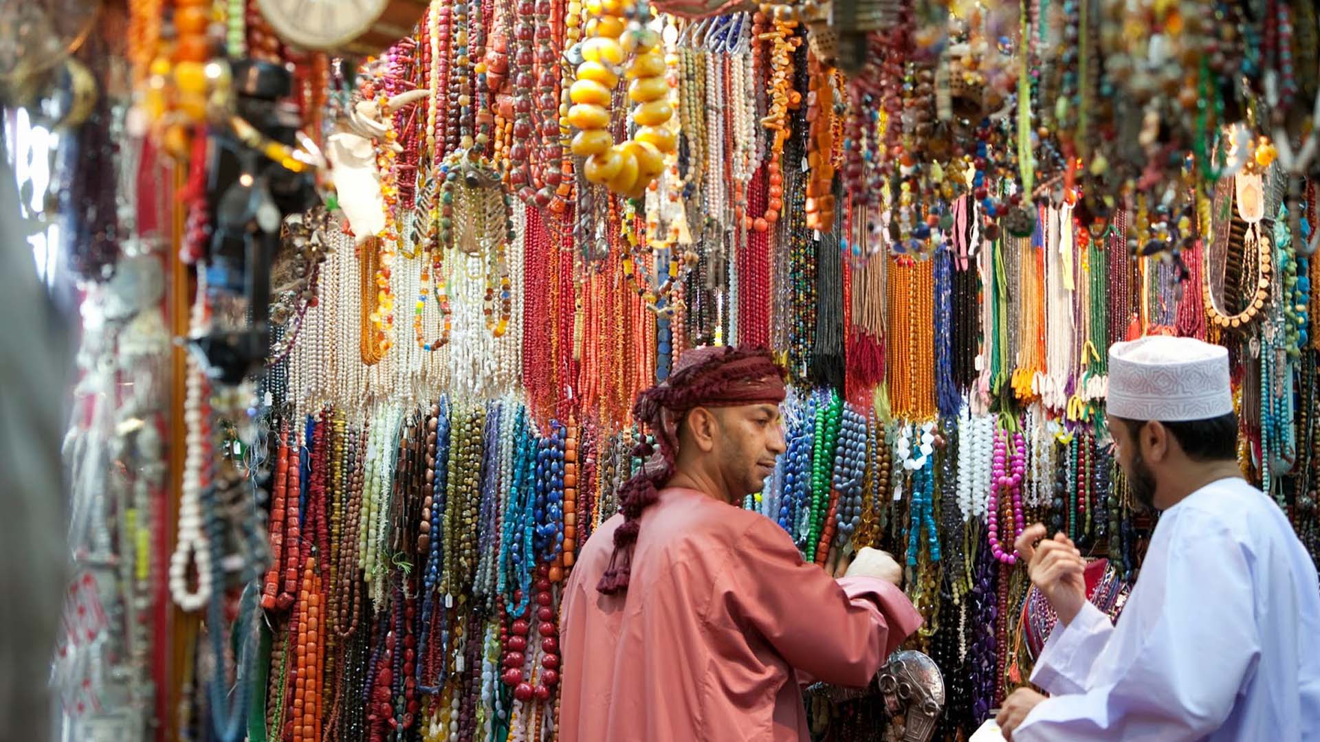 A panoramic photograph immortalizes the delightful shopping experience at a traditional shop in Muscat, where vibrant coloured beads overflow, creating a captivating scene.
