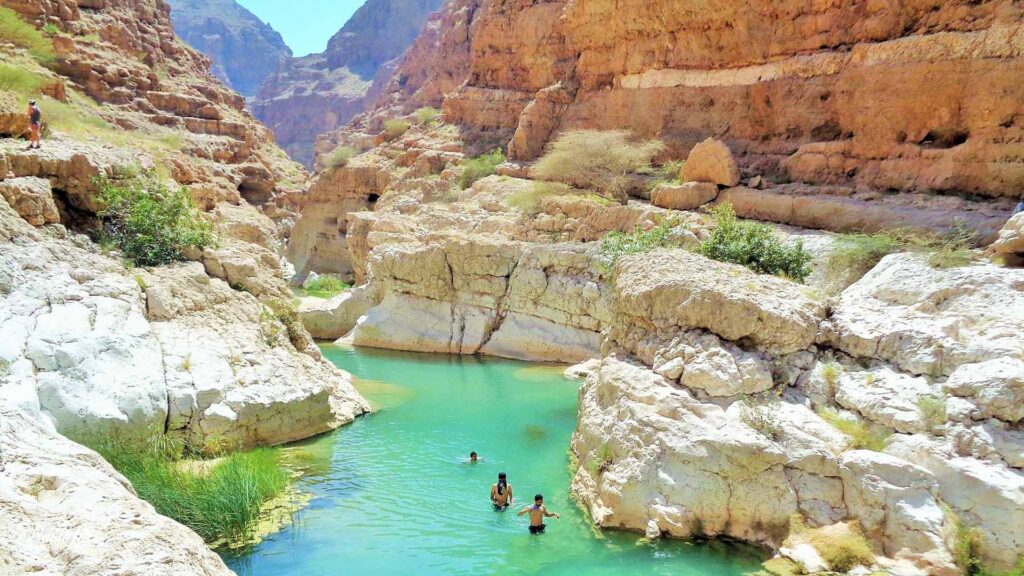 A panoramic photograph immortalizes the captivating beauty of Wadi Shab, where a meandering riverbed cuts through the rugged mountains.